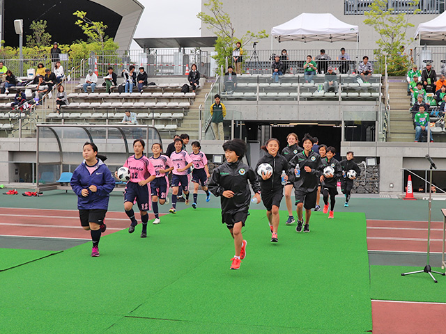 ボールパーソンを担当する駒沢学園女子中学・高等学校サッカー部の部員たち（左側）