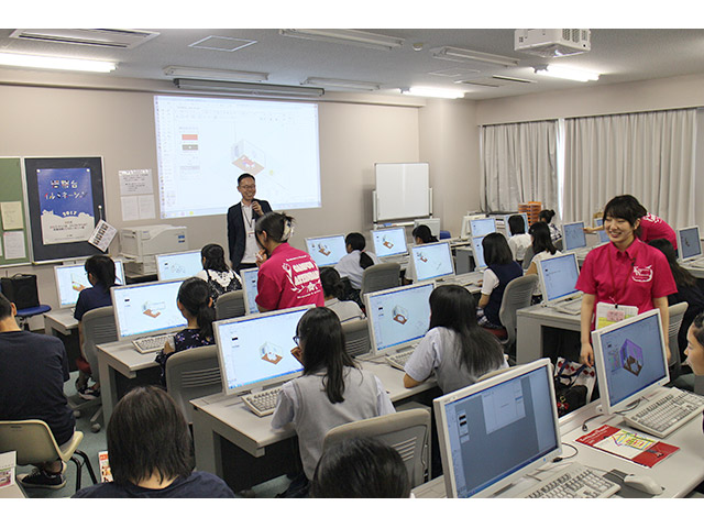 CAD実習室にてパソコンに向かう生徒さんを学生たちが丁寧にサポートします。