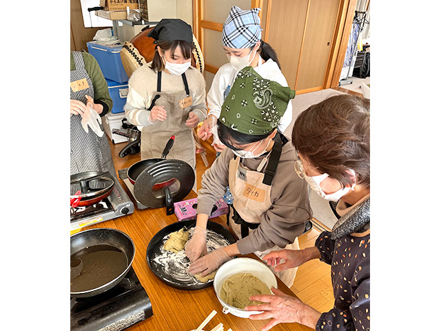 地元のお母さんたちに教わりながら調理中！