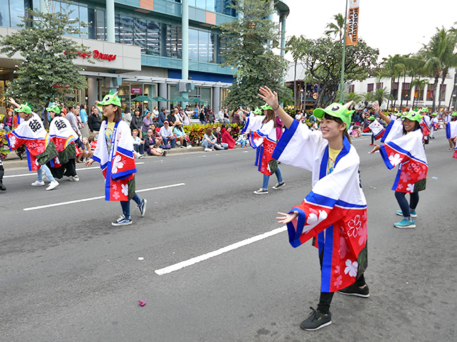 パレードで踊りながら行進する学生たち
