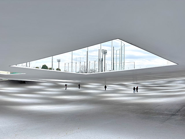 四角く切り取られた天井の開口部から落ちる光と影が傾斜する地面に模様を描いています