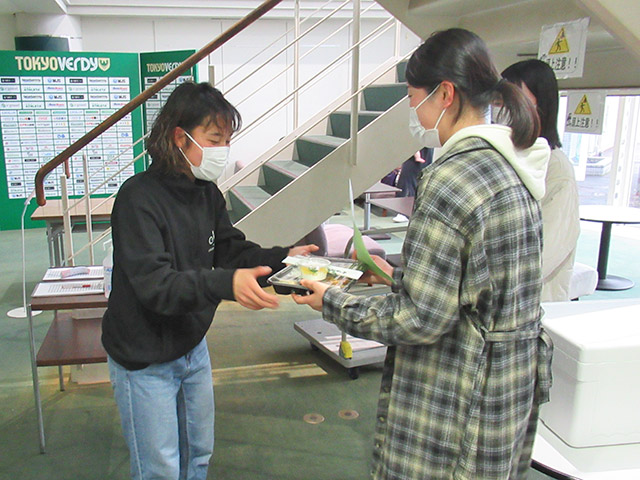 学生から選手にお弁当を渡す様子