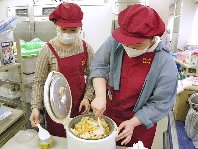 炊き立ての筍ご飯を混ぜる学生たち