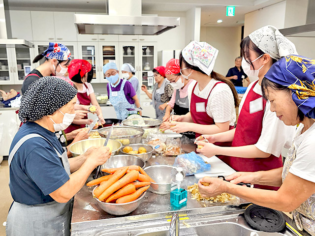 ボランティアの方々と調理する学生たち