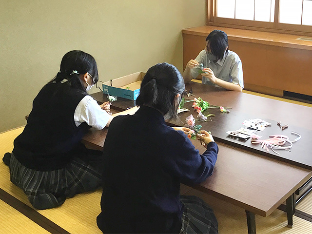 黙々と帯飾りを作る中学３年生