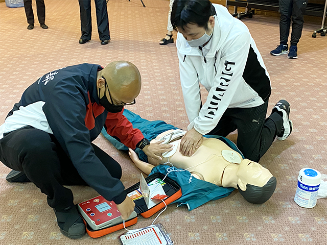 胸骨圧迫をしながら、AEDの装着