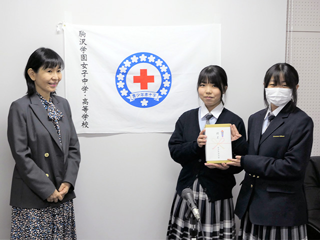 校長から高1代表に向けて赤十字バッジの授与
