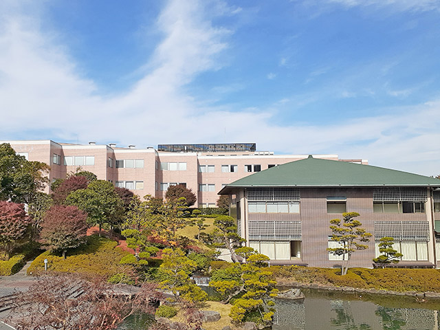 池の向こう側にある緑屋根の建物が仏教学で坐禅を行う照心館（坐禅堂）です。