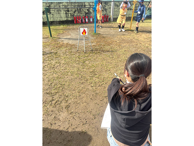 火災が起きている場所に水消火器を向けています