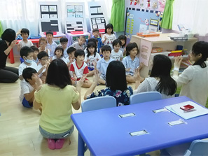 シンガポールの子どもたちといっしょに日本の手あそびを楽しみました（背中側が本学学生）。